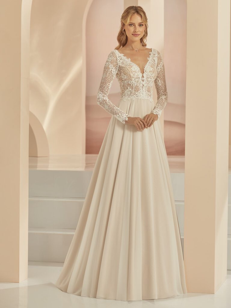 Das elegante A-Linie Brautkleid FAMOSA überzeugt mit einer perfekten Zusammensetzung hochwertiger Spitze und Chiffon. Das elegante langarm Hochzeitskleid hat einen modernen, doppelten V-Ausschnitt.